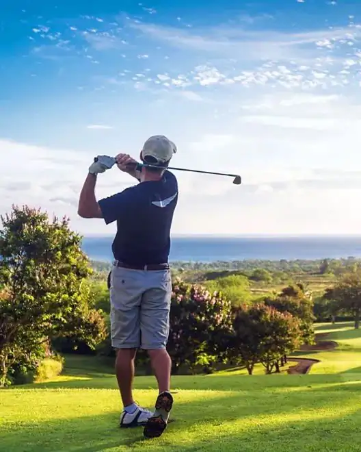 Golfista al termine dello swing con vista sul mare